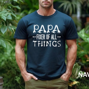 May include: A navy blue t-shirt with white text that reads "Papa - Fixer of All Things" with wrench and screwdriver graphics.