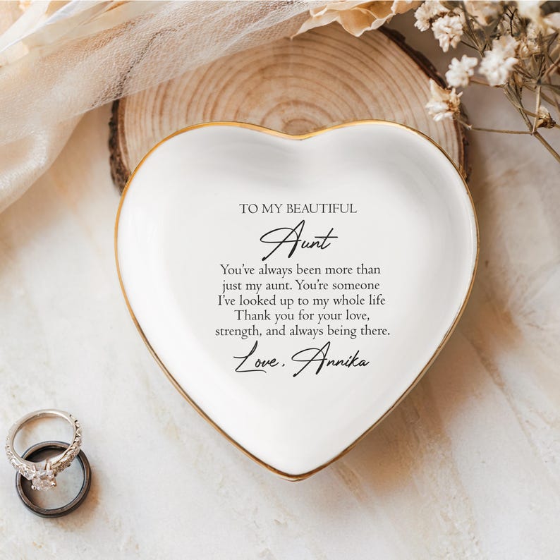 May include: White heart-shaped trinket dish with a gold rim. The dish has a message written on it that reads "To my beautiful Aunt You've always been more than just my aunt. You're someone I've looked up to my whole life. Thank you for your love, strength, and always being there. Love. Annika"