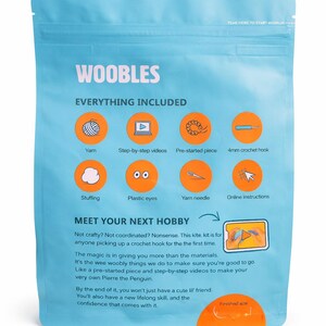 Puede incluir: Un paquete azul claro etiquetado como "WOOBLES" contiene todo lo necesario para un proyecto de ganchillo. El paquete incluye hilo, un ganchillo, relleno, ojos de pl&aacute;stico e instrucciones en l&iacute;nea. Tambi&eacute;n es visible el texto "MEET YOUR NEXT HOBBY".