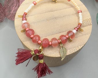 Elegant bracelet with pink pearls, gold-colored plates and tassel