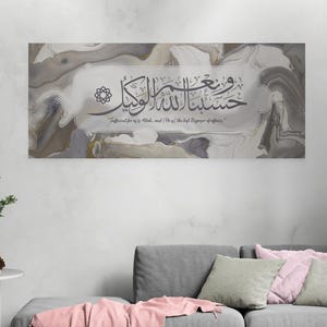 May include: A gray and white abstract art print with Arabic calligraphy that reads "Sufficient for us is Allah, and He is the best Disposer of affairs." The print is framed with a gray border.