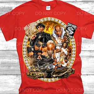 May include: A bright red t-shirt featuring a large circular graphic framed by diamonds. The design includes multiple figures, a military tank, a luxury sports car, and a black rectangular sign with the text Cash Money Records in white lettering.