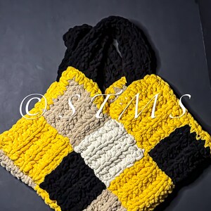 May include: A crocheted tote bag with a checkered pattern in yellow, black and beige.