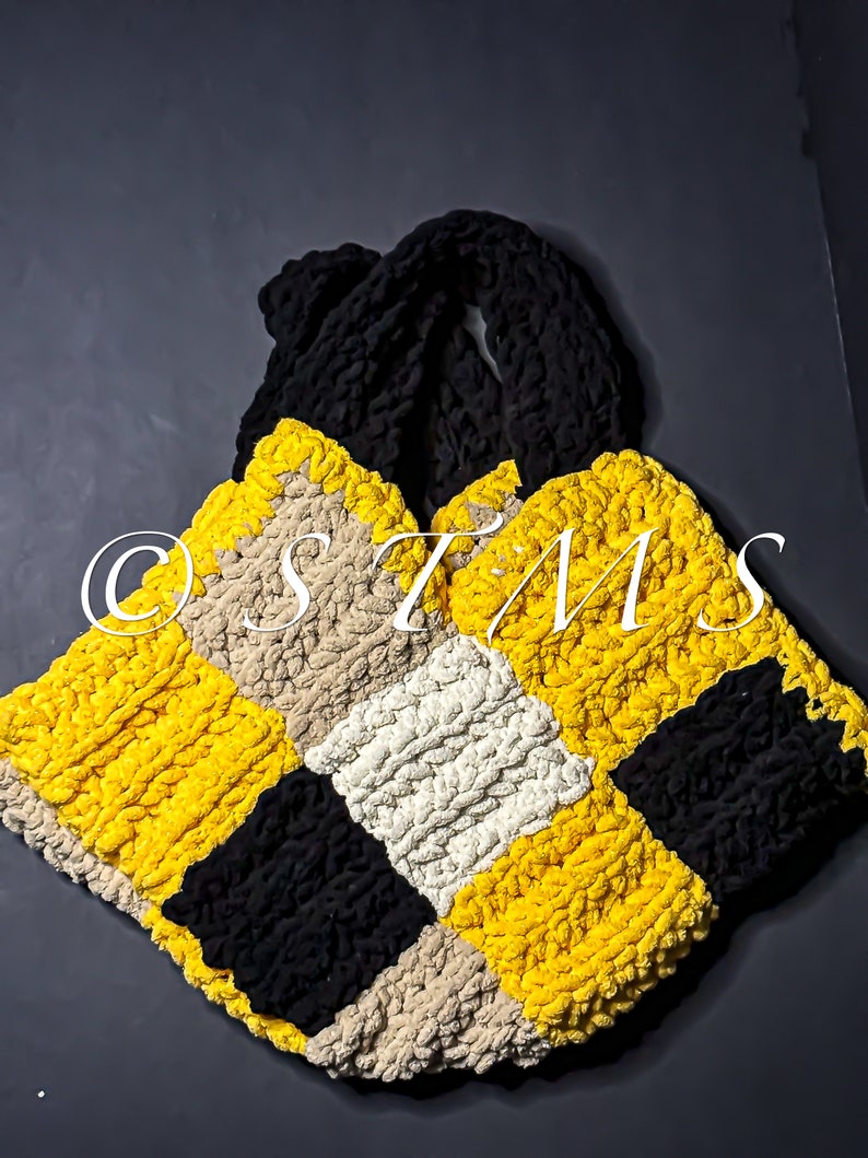 May include: A crocheted tote bag with a checkered pattern in yellow, black and beige.