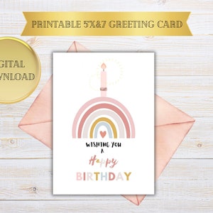Puede incluir: Tarjeta de cumpleaños imprimible con un arcoíris con una vela encendida en la parte superior y el texto "Wishing you a Happy Birthday".