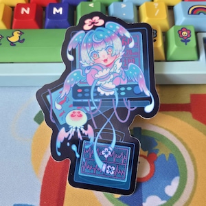 May include: A die-cut sticker featuring a stylized anime-inspired character with light blue hair and wings, positioned in front of a dark blue computer monitor displaying a heart rate monitor graphic with pink lines and a small flower icon.