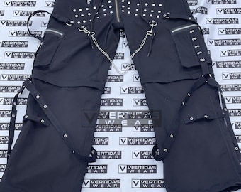 May include: Black cargo pants with multiple straps, buckles, and a silver chain. The pants have a zipper fly and a drawstring waistband. The pants are decorated with silver studs.