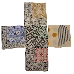 Puede incluir: Cinco cuadrados de tela con diferentes patrones. Los cuadrados son todos blancos con contornos negros y presentan varios diseños geométricos en azul, verde, rojo y amarillo.