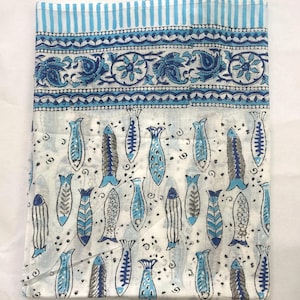 Peut inclure: Tissu blanc plié avec un motif de poissons bleus. Le tissu a une bordure avec des motifs floraux et cachemire dans des tons de bleu. Le bord supérieur présente des rayures bleues et blanches.