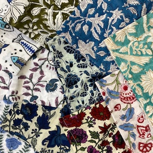 Puede incluir: Una colección de muestras de tela con varios patrones florales y botánicos. Las telas presentan una gama de colores, incluyendo azul, blanco, verde y rojo. Los diseños incluyen flores estilizadas, hojas y otros elementos naturales.