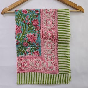 Può includere: Una sciarpa di cotone a righe verdi e bianche con una stampa floreale rosa e blu. La sciarpa ha un bordo di disegni floreali rosa e bianchi.