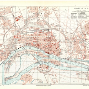 May include: A vintage map of Magdeburg, Germany, printed in black, red, and blue ink on white paper. The map shows the city's streets, buildings, and waterways. The title "MAGDEBURG" is printed in bold at the top of the map. The map is dated "Mai 1930" in the upper right corner.