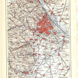 Könnte beinhalten: Antike Karte von Wien, Österreich, mit detaillierter Kartografie. Die Karte zeigt ein Netzwerk von Straßen, Flüssen und Städten, wobei das Stadtzentrum rot hervorgehoben ist. Die Karte enthält Text auf Deutsch und ist gerahmt.