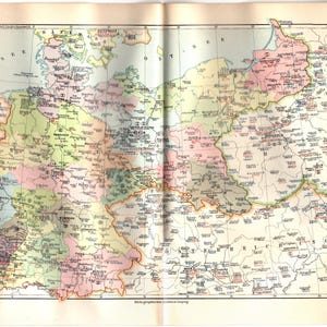 May include: A vintage map of Central Europe, featuring detailed geographical information. The map is folded and shows various countries in different colors, with text in German. The map's title is "Garnisonskarte von Mitteleuropa."
