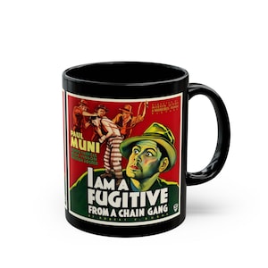 May include: A black ceramic mug featuring the vintage movie poster for I Am a Fugitive from a Chain Gang. The graphic displays a man in a hat, a chain gang scene, and the title text in bold white letters against a red and green background.