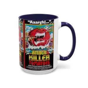 May include: White ceramic coffee mug with a blue rim and handle. The mug features a colorful illustration of a giant, red, toothy tomato with the text "Aaargh!… ATTACK of the KILLER TOMATOES A New Musical-Comedy-Horror Show".