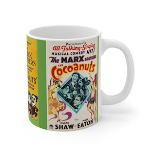 May include: White ceramic mug featuring a vintage movie poster design for "The Cocoanuts" starring The Marx Brothers. The poster has a colorful design with text and illustrations, including the names of the actors and the movie title.