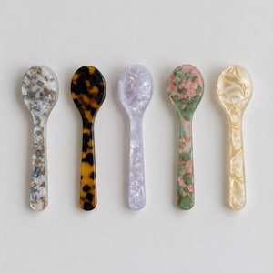 Pode incluir: Cinco colheres pequenas dispostas em fila, cada uma com um padr&atilde;o de m&aacute;rmore ou tartaruga distinto. As cores incluem uma mistura de azul e branco, um tartaruga cl&aacute;ssico castanho e preto, um lavanda claro, uma mistura de verde e rosa e um creme.