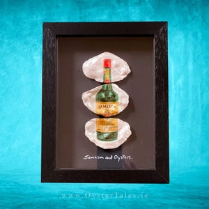 Può includere: Opera d'arte incorniciata con tre bottiglie di Jameson Irish Whiskey presentate in conchiglie di ostrica su sfondo nero. L'opera è racchiusa in una cornice di legno nera. Il testo "Jameson and Oysters" è scritto sull'opera.