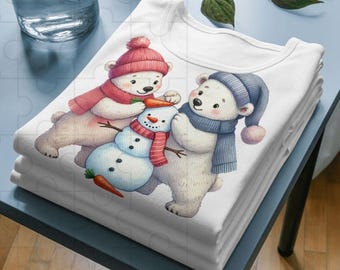 May include: A stack of white t-shirts featuring a whimsical illustration of polar bears building a snowman. The bears wear winter hats and scarves in shades of red and blue. The snowman has a carrot nose and twig arms.