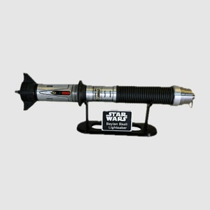 May include: A silver and black lightsaber with a black stand and a black label that reads "STAR WARS Baylan Skoll Lightsaber".
