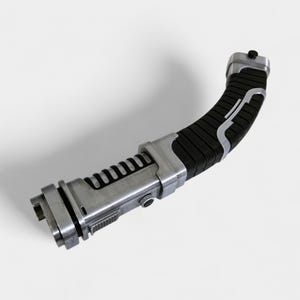 May include: A silver and black lightsaber prop with a curved handle. The handle is black with silver accents and a ribbed texture. The body of the lightsaber is silver with a series of black ridges.