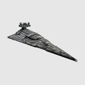 May include: A detailed model of a Star Destroyer spaceship, featuring a gray color scheme with intricate surface detailing. The model has a triangular shape with a long, pointed front and a command tower. The spaceship is a collectible item.