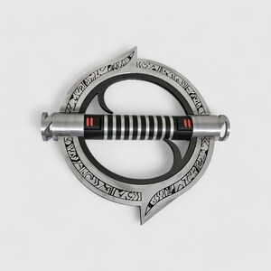 May include: A silver lightsaber with a black handle and red accents. The lightsaber is attached to a circular, silver, metal ring with intricate designs.