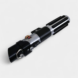 May include: A replica lightsaber with a black handle, silver accents, and a detailed emitter. The hilt features various buttons, switches, and a ring at the base. The top has a silver finish with black ridges. A prop from a science fiction movie.