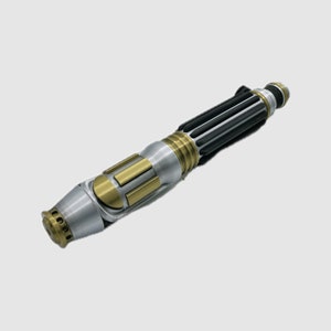 May include: A silver and black lightsaber with a gold handle and a textured black grip. The lightsaber has a round, silver emitter with a series of small holes.