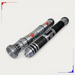 May include: Two cylindrical metal props with intricate detailing. One features a silver finish with two prominent red buttons and a fluted base. The other has a black ribbed grip section and a silver body with a textured, perforated metal overlay.