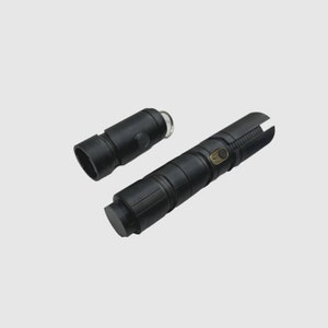 May include: A black lightsaber with a removable handle. The handle has a gold button and a black ring.