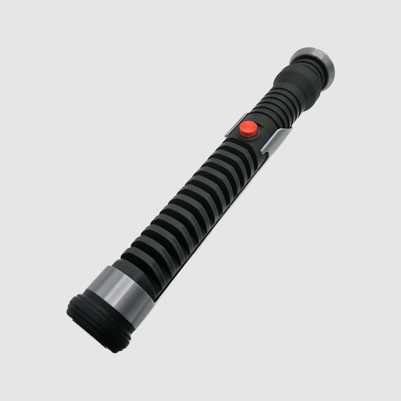 May include: A black lightsaber with a silver band and a red button. The lightsaber has a textured, ribbed design.