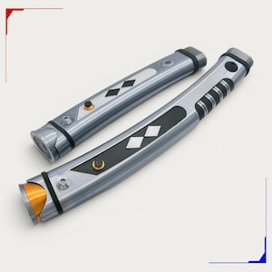 Peut inclure: Deux poign&eacute;es de sabre laser en m&eacute;tal argent&eacute; au design incurv&eacute;. Chaque poign&eacute;e pr&eacute;sente des sections de prise noires, des boutons circulaires dor&eacute;s et des accents en forme de losange. Finitions m&eacute;talliques avec vis et extr&eacute;mit&eacute;s filet&eacute;es.