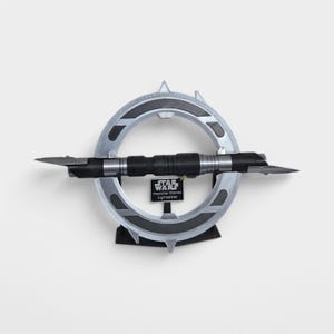May include: A silver and black lightsaber with a circular stand. The lightsaber is labelled "Star Wars Inquisitor Marrok Lightsaber".