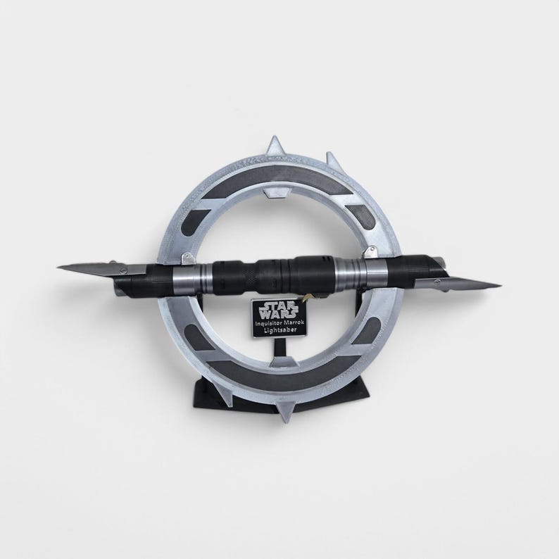 May include: A silver and black lightsaber with a circular stand. The lightsaber is labelled "Star Wars Inquisitor Marrok Lightsaber".