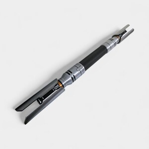 May include: A silver and black lightsaber prop with a textured black grip. The hilt features silver accents and a blade emitter with a split design. The overall design is futuristic and detailed, with a focus on metallic elements.