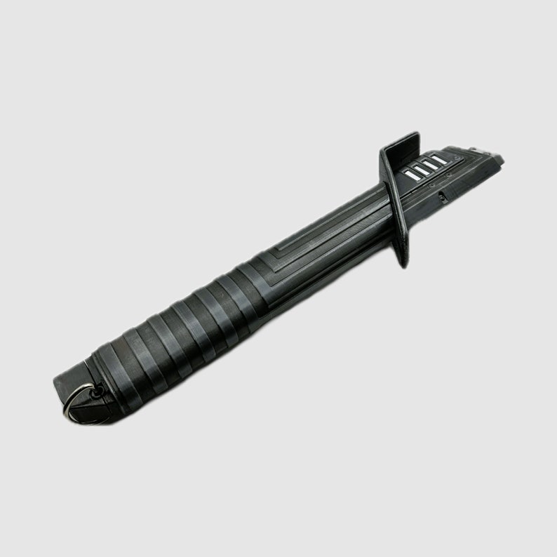 Op de afbeelding: Zwarte lightsaber-handvat met een getextureerde grip en een zilveren ring aan het einde. Het handvat heeft een zwart-zilver ontwerp met een reeks groeven.