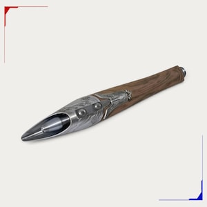 May include: A writing pen featuring a brown wood-grain barrel and a metallic silver-toned front section. The silver component displays intricate embossed floral patterns and a pointed, tapered tip that partially encases the pen nib.
