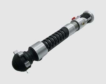May include: A silver and black lightsaber with a black handle and a silver blade. The lightsaber has a red button on the side.