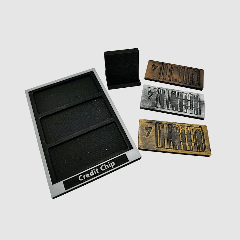 May include: A silver tray with three compartments labeled "Credit Chip".  The tray is used to hold three credit chips, each with a different design. The chips are made of wood and have a black and white design.