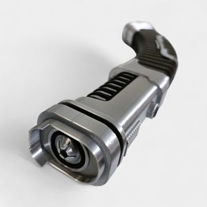 May include: A metallic silver and black device with a curved handle and a detailed, industrial design. The device has a textured grip, a series of black ridges, and a circular end with a central component.