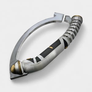 May include: A silver and black lightsaber hilt with a curved handle. The hilt features a black grip with silver accents, a ribbed section, and gold-colored details. The design is futuristic and detailed.