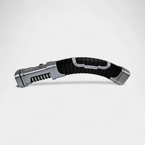 May include: A silver and black lightsaber prop with a curved handle. The handle has a textured black grip with silver accents. The end of the hilt is silver, and the blade emitter is also silver with a series of black ridges.