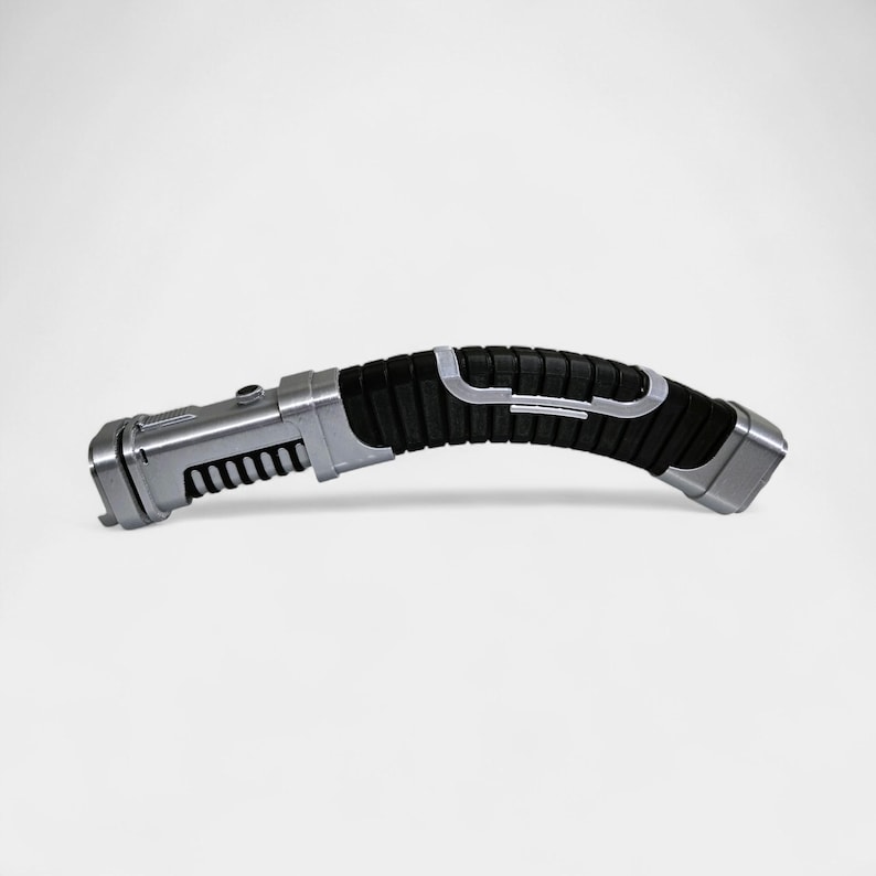 May include: A silver and black lightsaber prop with a curved handle. The handle has a textured black grip with silver accents. The end of the hilt is silver, and the blade emitter is also silver with a series of black ridges.