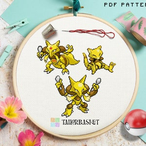 Könnte beinhalten: Ein Kreuzstichmuster mit drei gelb-braunen Zeichentrickfiguren mit Löffeln, in einem Stickrahmen. Der Text "PDF PATTERN" steht oben, und das TailorBasket-Logo unten. Enthält einen Fingerhut, eine Nadel und roten Faden.