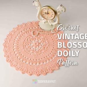 May include: A crocheted peach-colored doily with a delicate floral pattern. The doily is on a white surface with a vintage clock and a pearl necklace on top of it. The text "Crochet Vintage Blossom Doily Pattern" is written in black on the right side of the image.