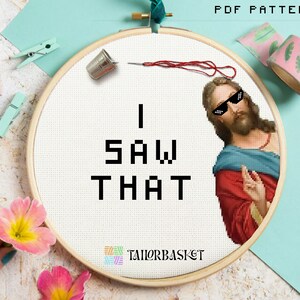 May include: A white embroidery hoop with a cross-stitch design that says "I SAW THAT" in black pixelated letters. A picture of Jesus wearing sunglasses is on the right side of the hoop.