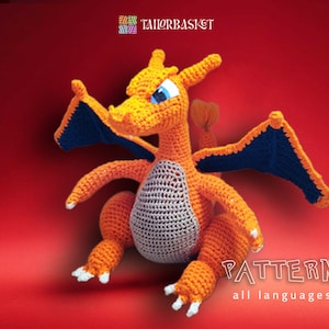 May include: A crocheted orange and gray dragon with blue wings. The dragon is sitting on a red background. The text "PATTERN all languages" is at the bottom of the image.