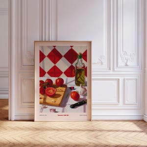 May include: A framed painting of a still life with red tomatoes, a bottle of olive oil, garlic cloves, and a knife on a wooden cutting board. The background is a red and white checkered tile pattern. The painting is titled "Tomatoes Still Life".